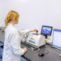 woman in a white lab coat operating a machine to examine supplement ingredients